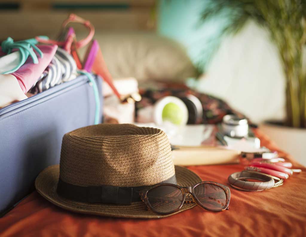 Hat and travel items on bed