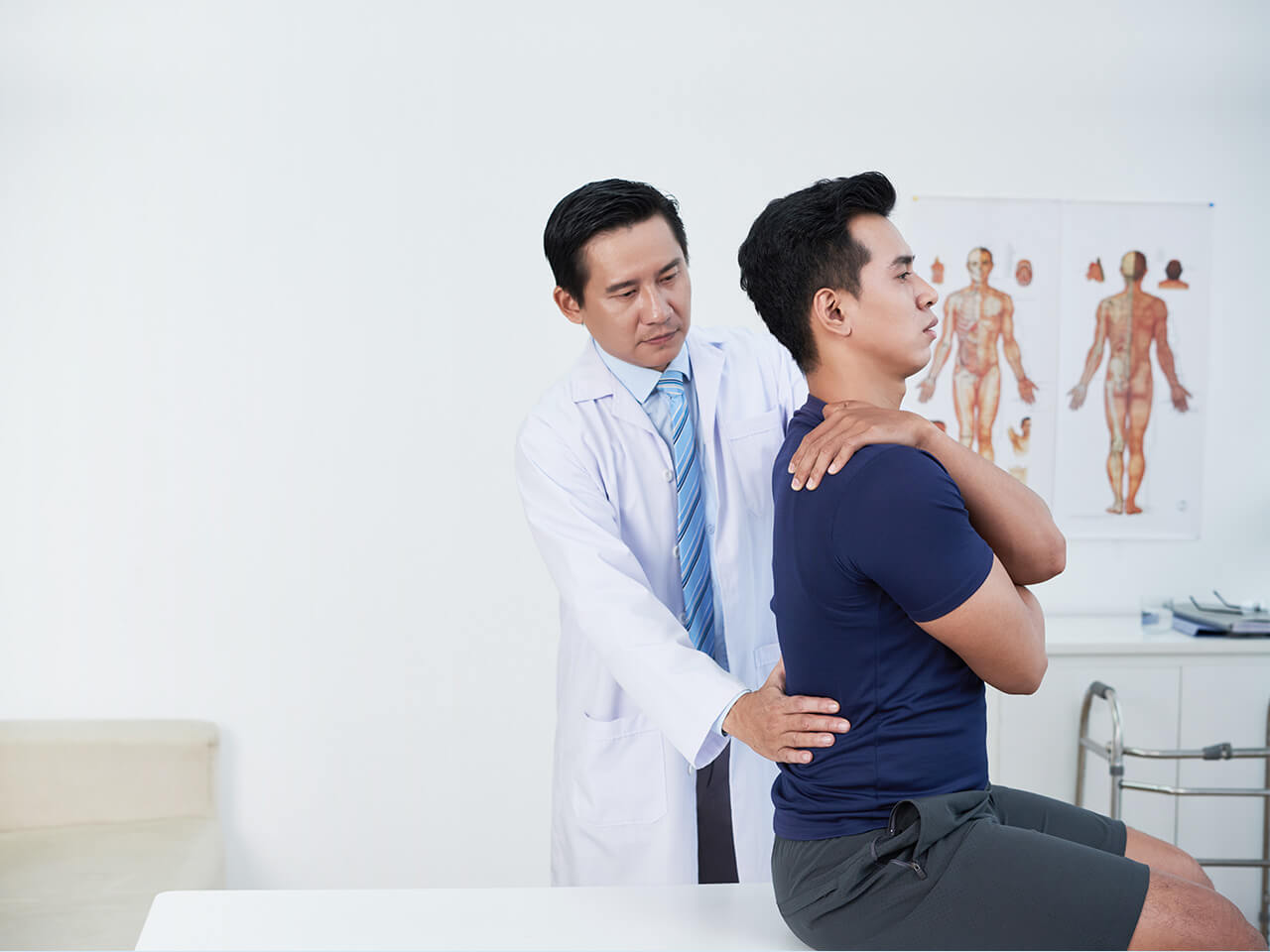 Doctor assessing a man's spine