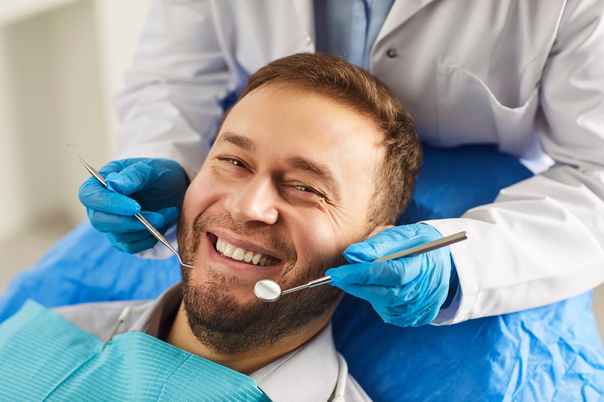 Happy man smiling while being on dental check_1200x800
