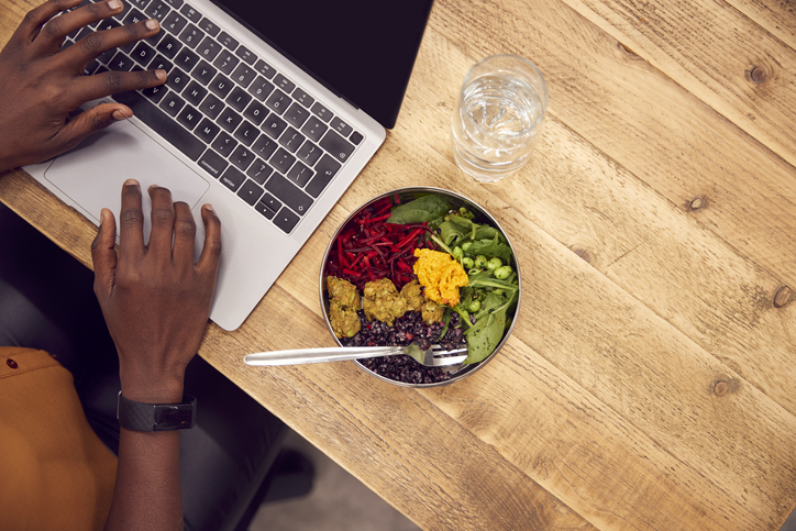 Bowl of food on a desk with laptop