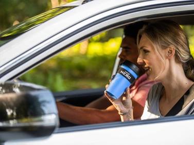 Woman drinking coffee in car