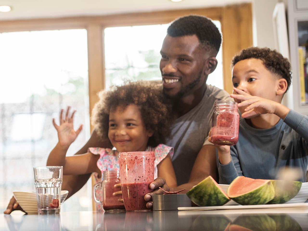 Decorative image of a father and his two children, laughing in the kitchen