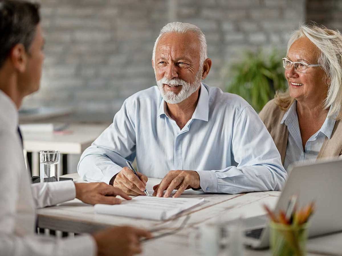 An elderly man and lady talking to a doctor