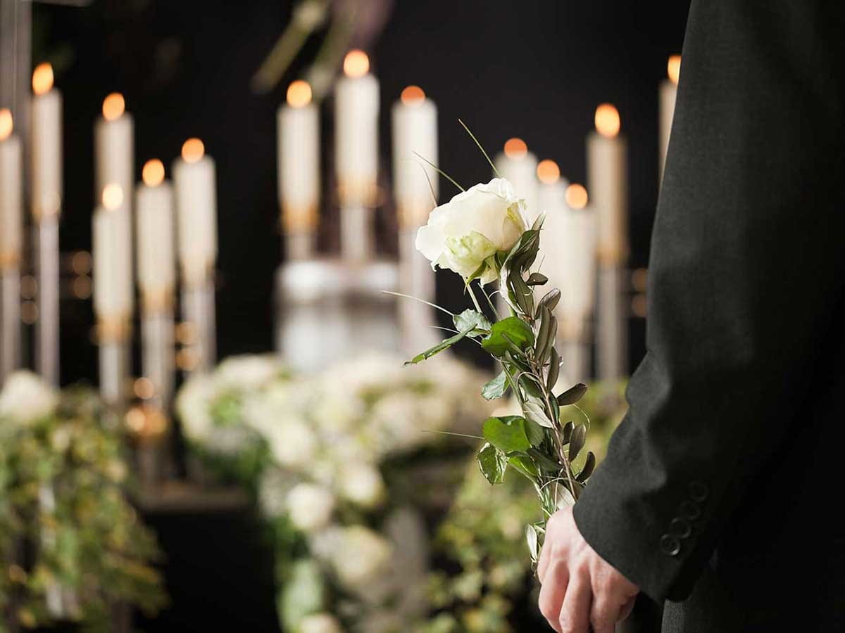 Man standing by candles and flowers