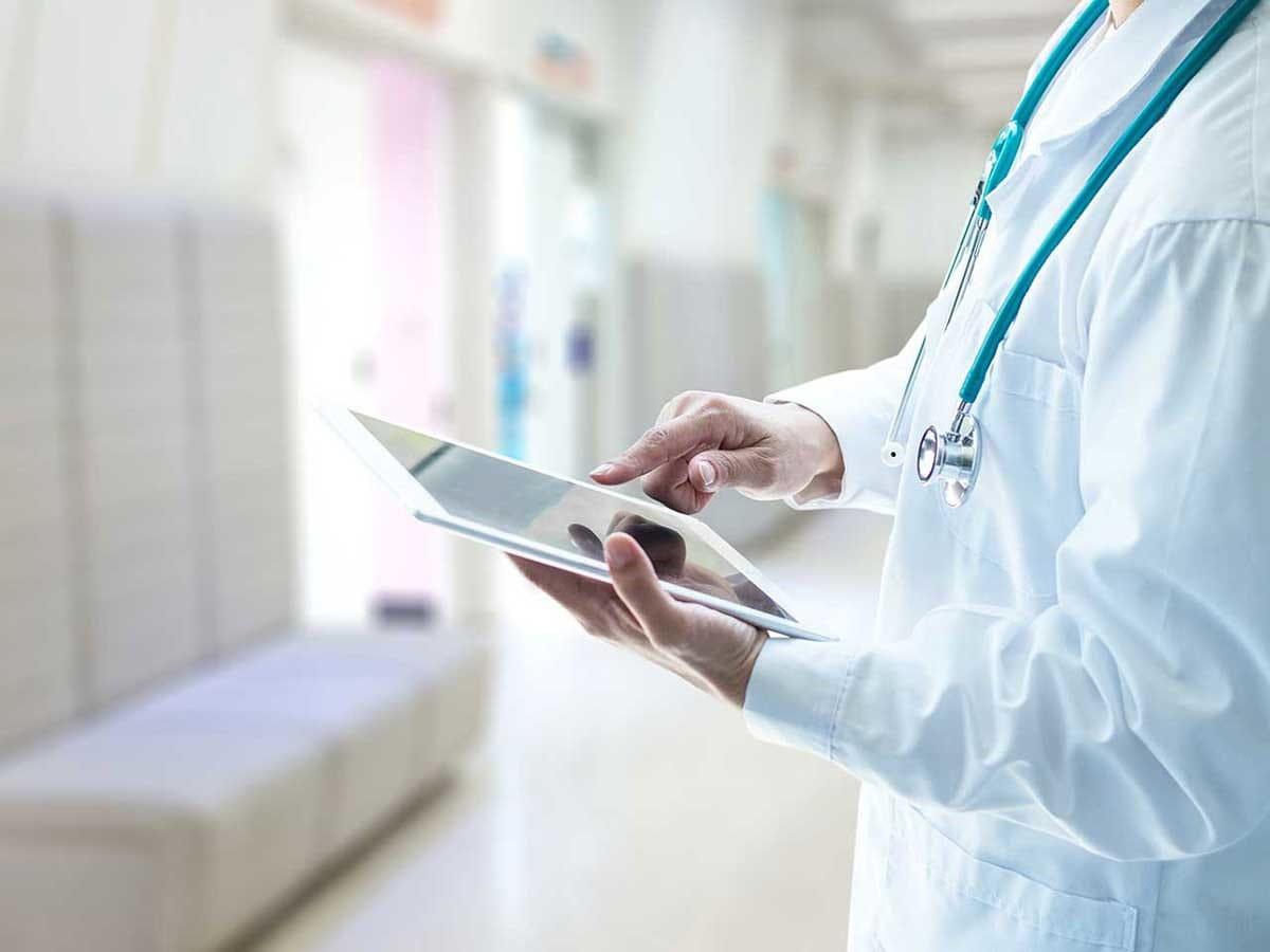 A doctor is looking at his ipad