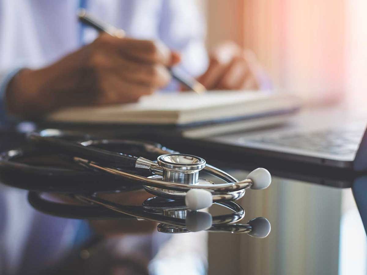 A doctor taking notes at his desk 