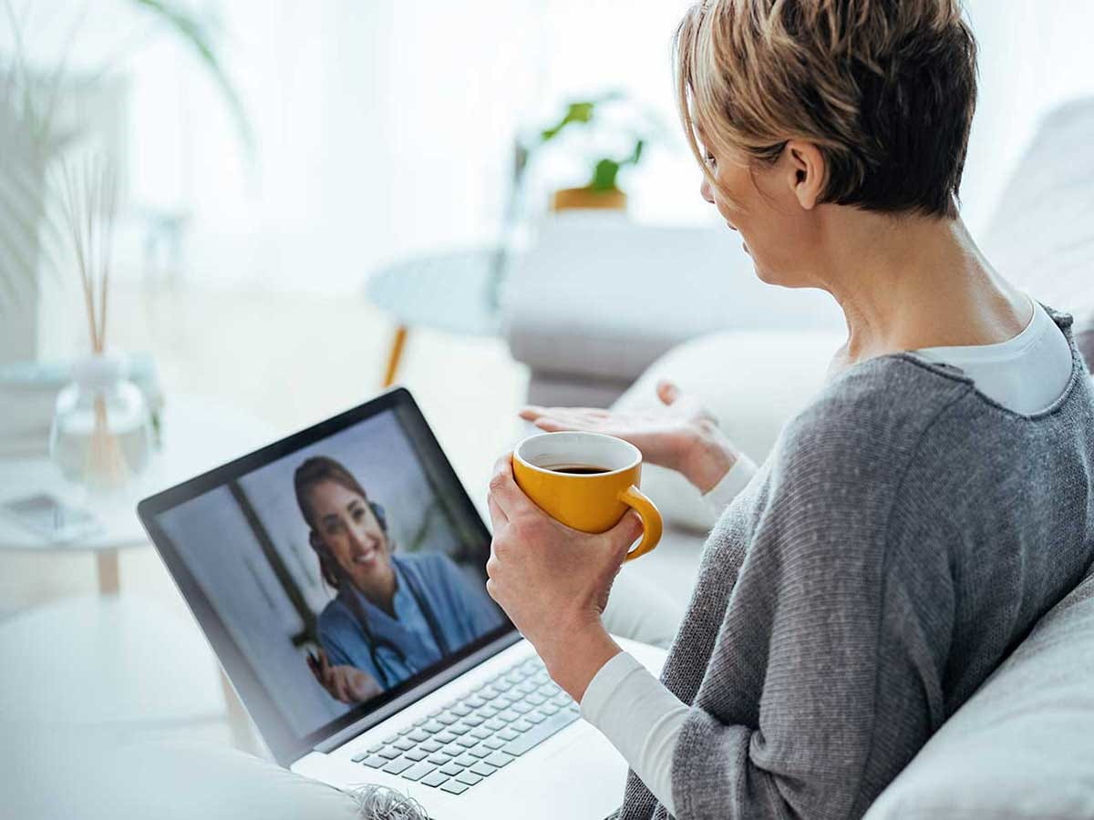 Woman on a zoom call with a coffee in her hand 