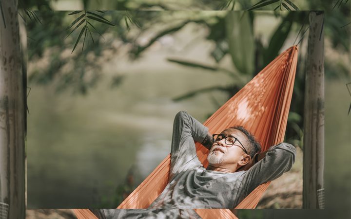 Black man in hammock laying and relaxing in the sun