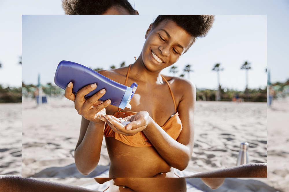 Black woman applying sun lotion