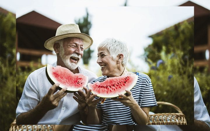 Older couple eating watermelon and laughing