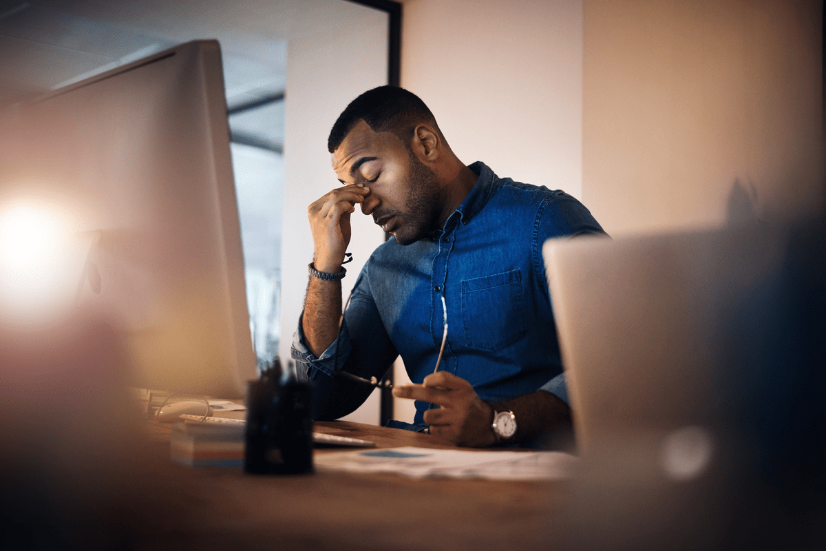 Shot of a young businessman looking stressed out while working in an office at night