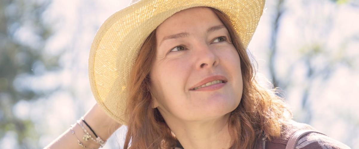 woman-smiling-outside-in-a-sun-hat