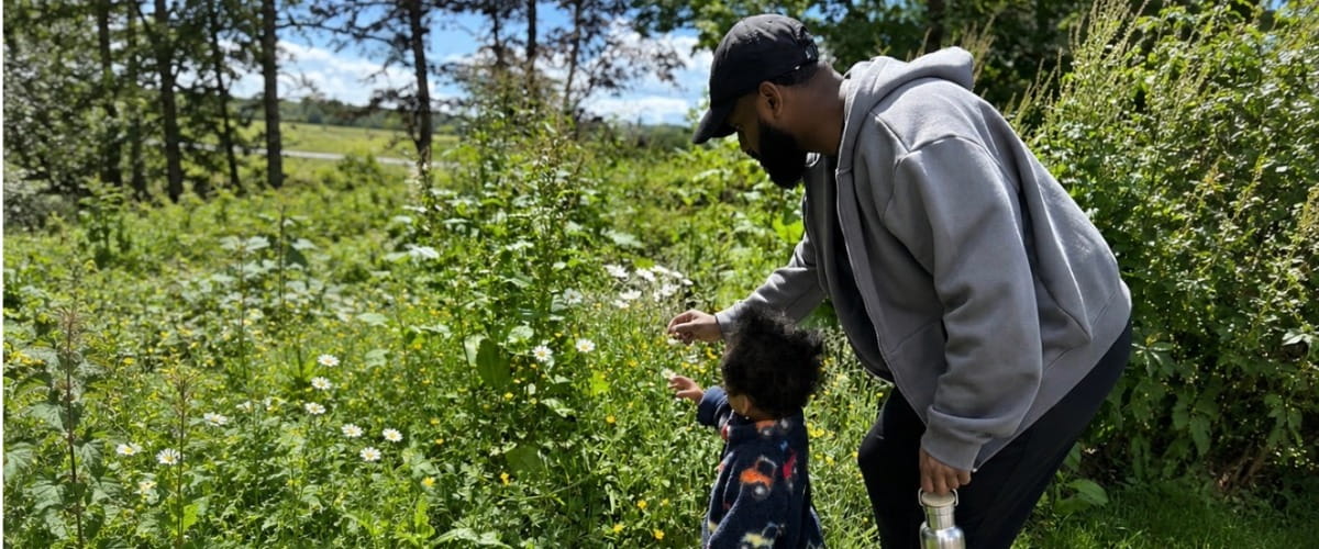 dad and son looking at flowers in summer