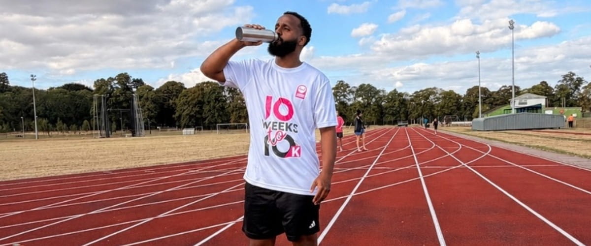 man drinking water whilst exercising