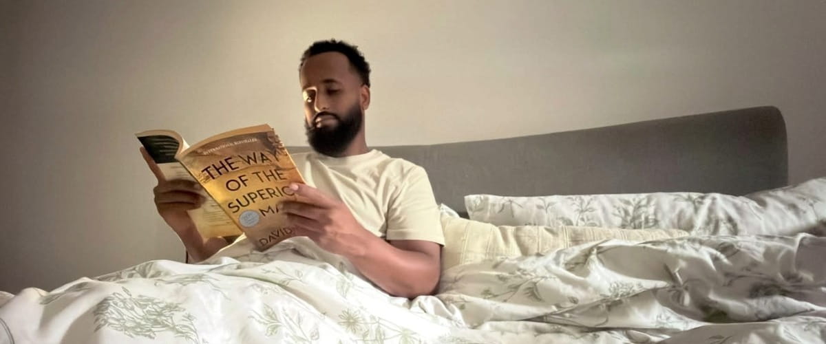 man reading in bed before sleep