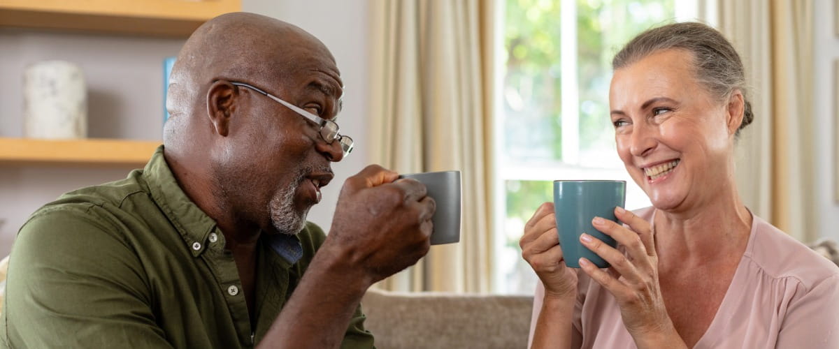Man and woman smiling drinking coffee