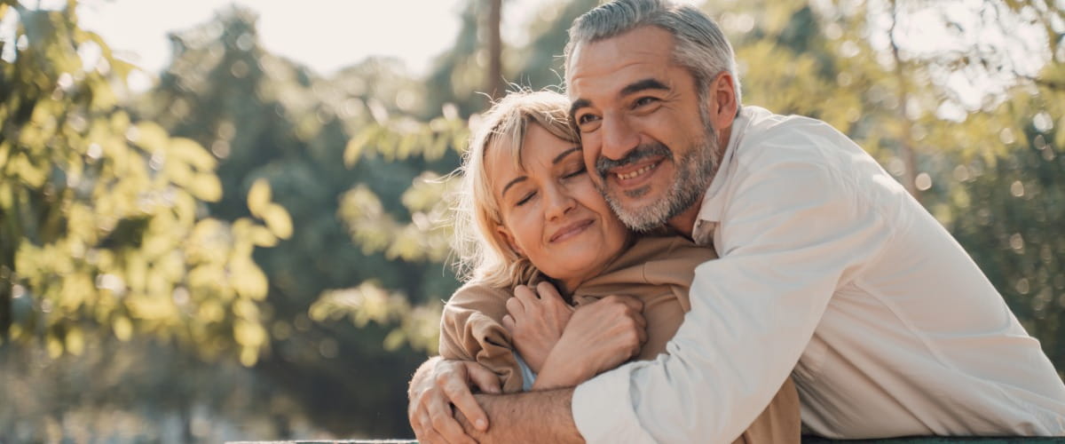 Man cuddling woman in the park