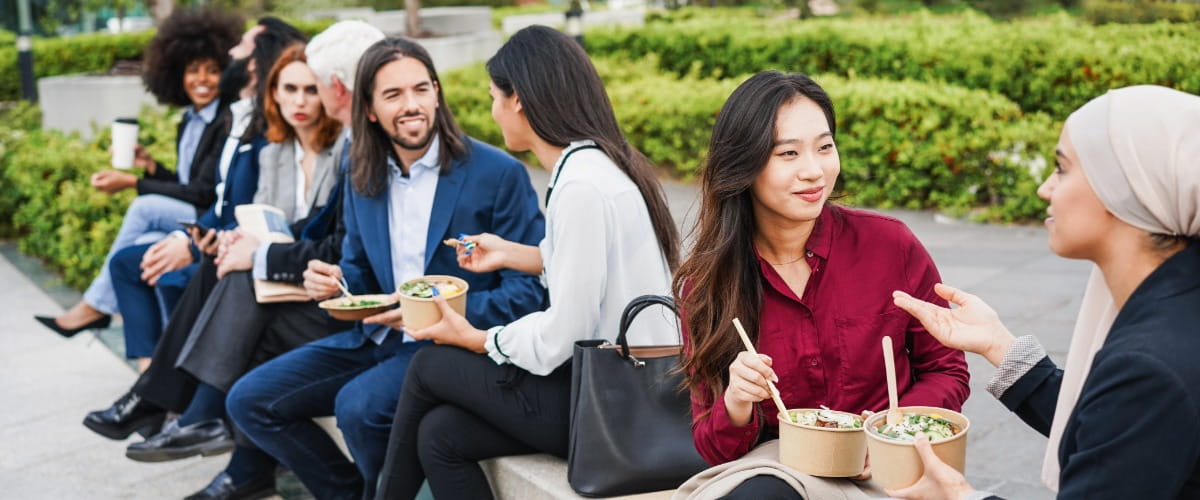 group-of-colleagues-eating-lunch-outside-together