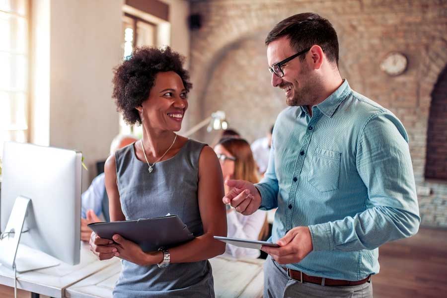 Man and woman talking in the office with a tablet