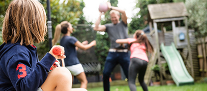 Decorative image of a family playing in their garden